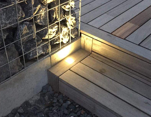 Marche d'escalier en Padouk avec intégration d'un spot dans la ceinture